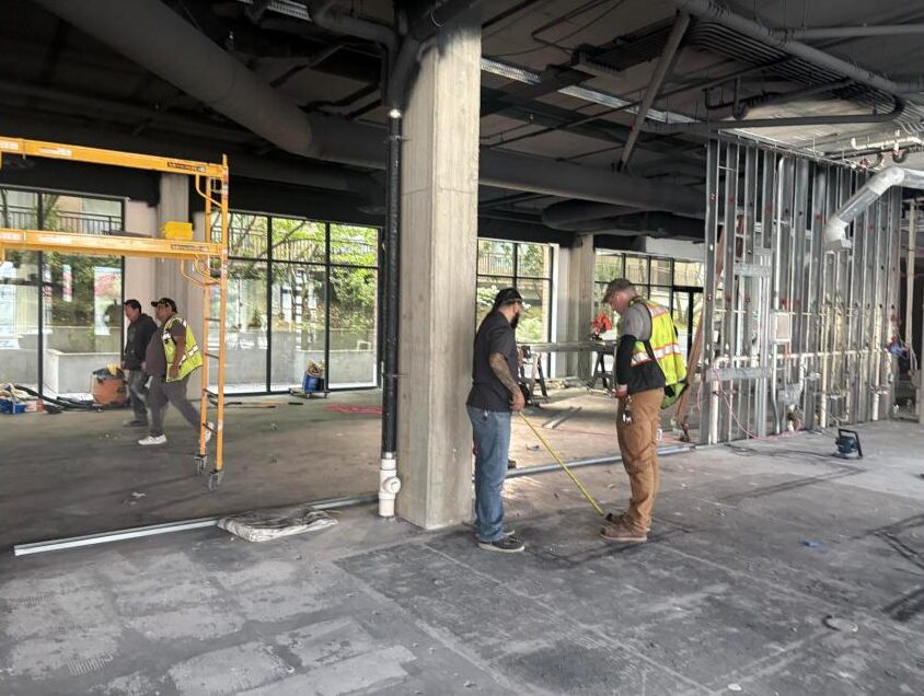 Crew measuring wall layout at 10708 Main Street, October 2026